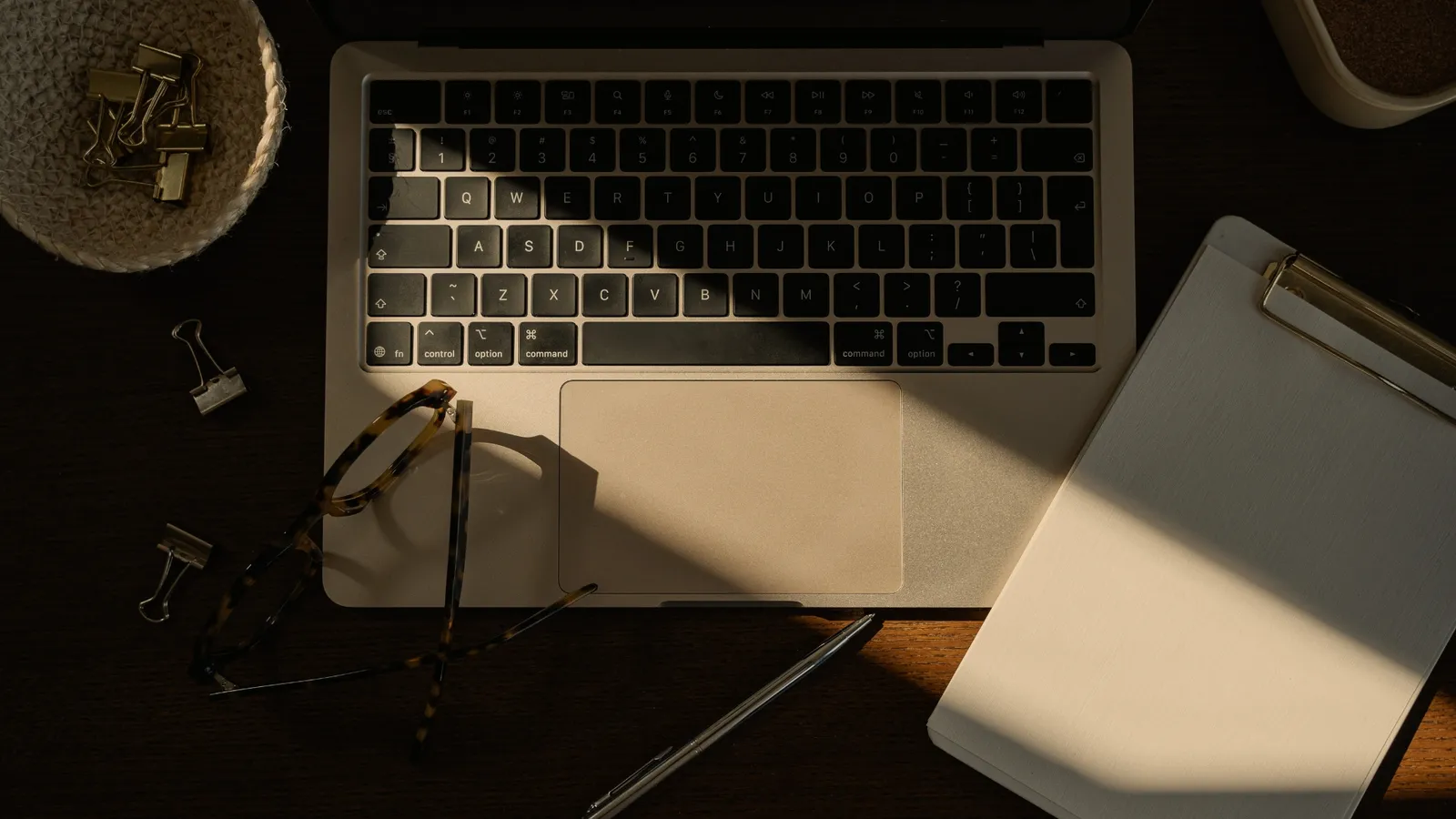 notebook na mesa com oculos
